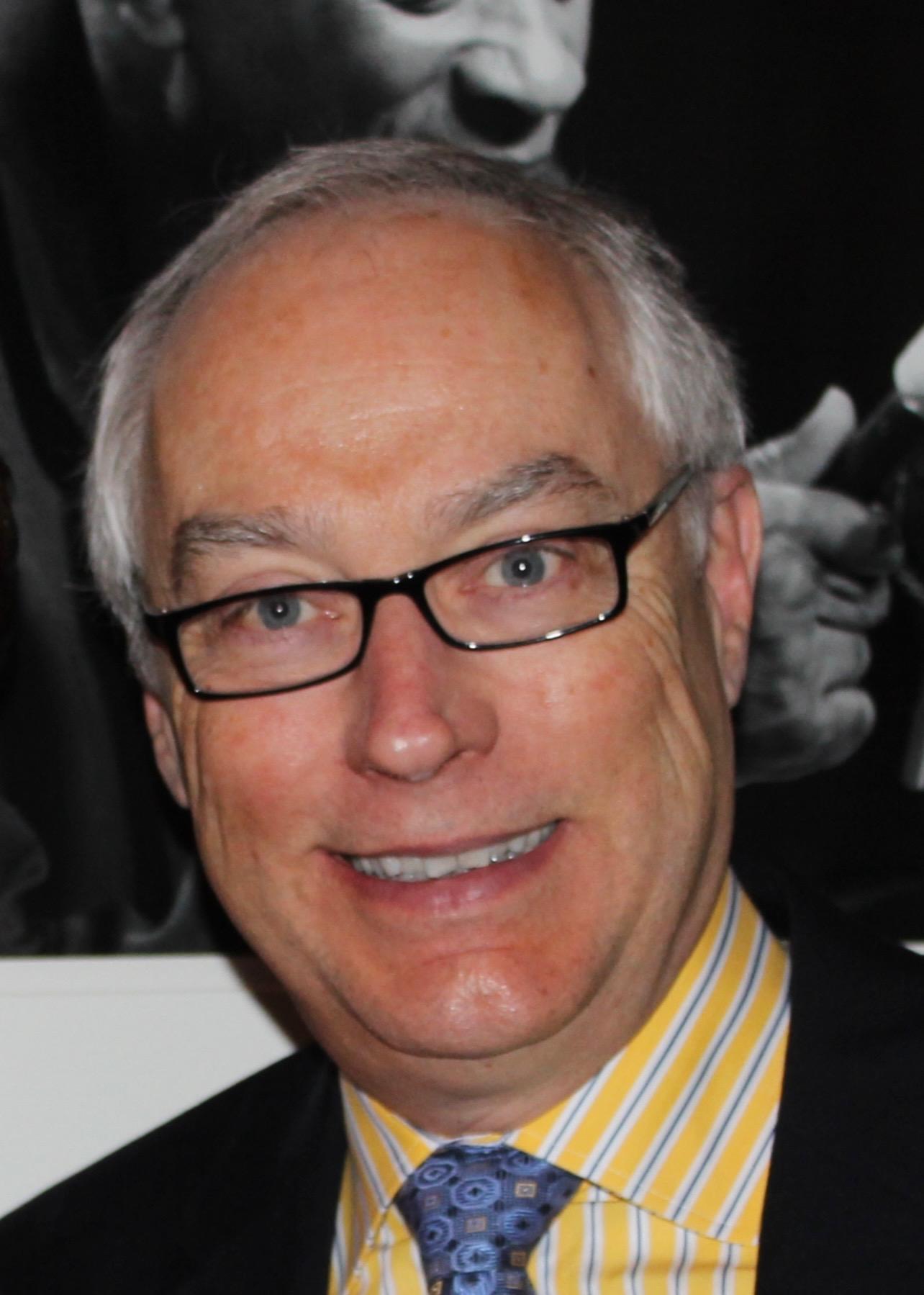 Close-up portrait of Dr. Robert Janowski, a dentist, smiling warmly.