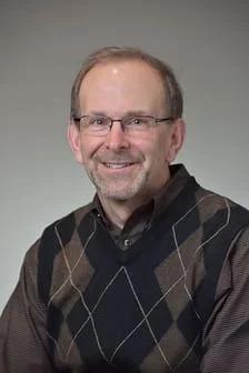 Close-up portrait of Dr. Robert Janowski, a dentist, smiling warmly.